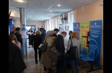 Stoisko informacyjne Państwowej Inspekcji Pracy podczas konferencji.